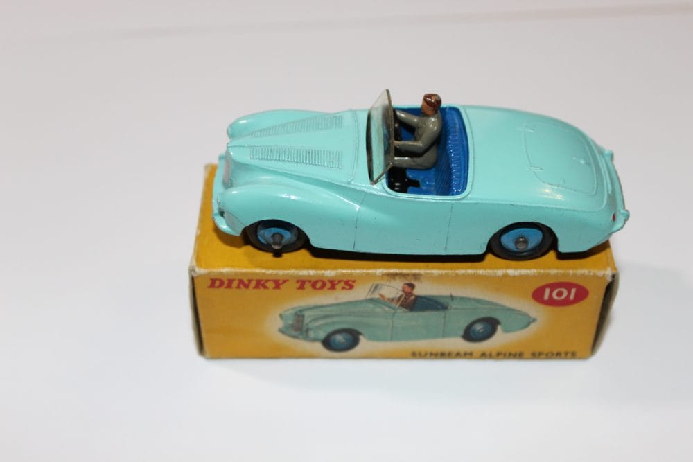 Vintage Dinky Toys Sunbeam Alpine model car on original box, collectible diecast vehicle.