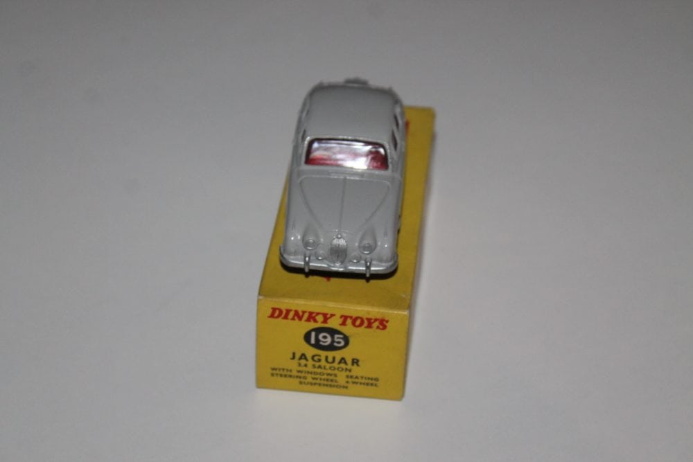 Dinky Toys 195 Grey Jaguar 3.4 model car on yellow display stand.