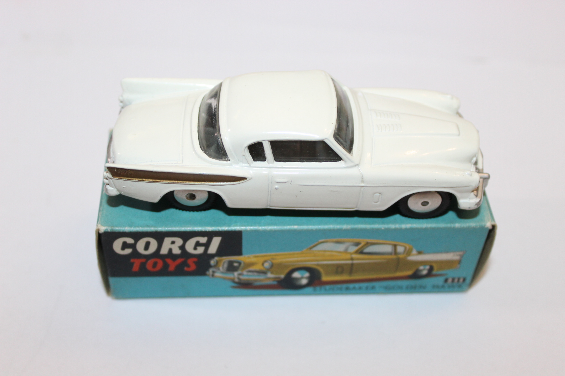 Vintage Corgi Toys diecast white car on original box, collectible model.