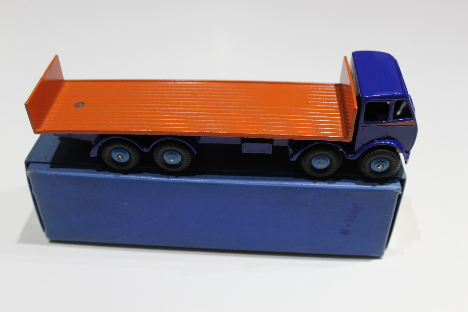Dinky Toys 503 model flat truck with orange bed and blue cab, detailed scale model.