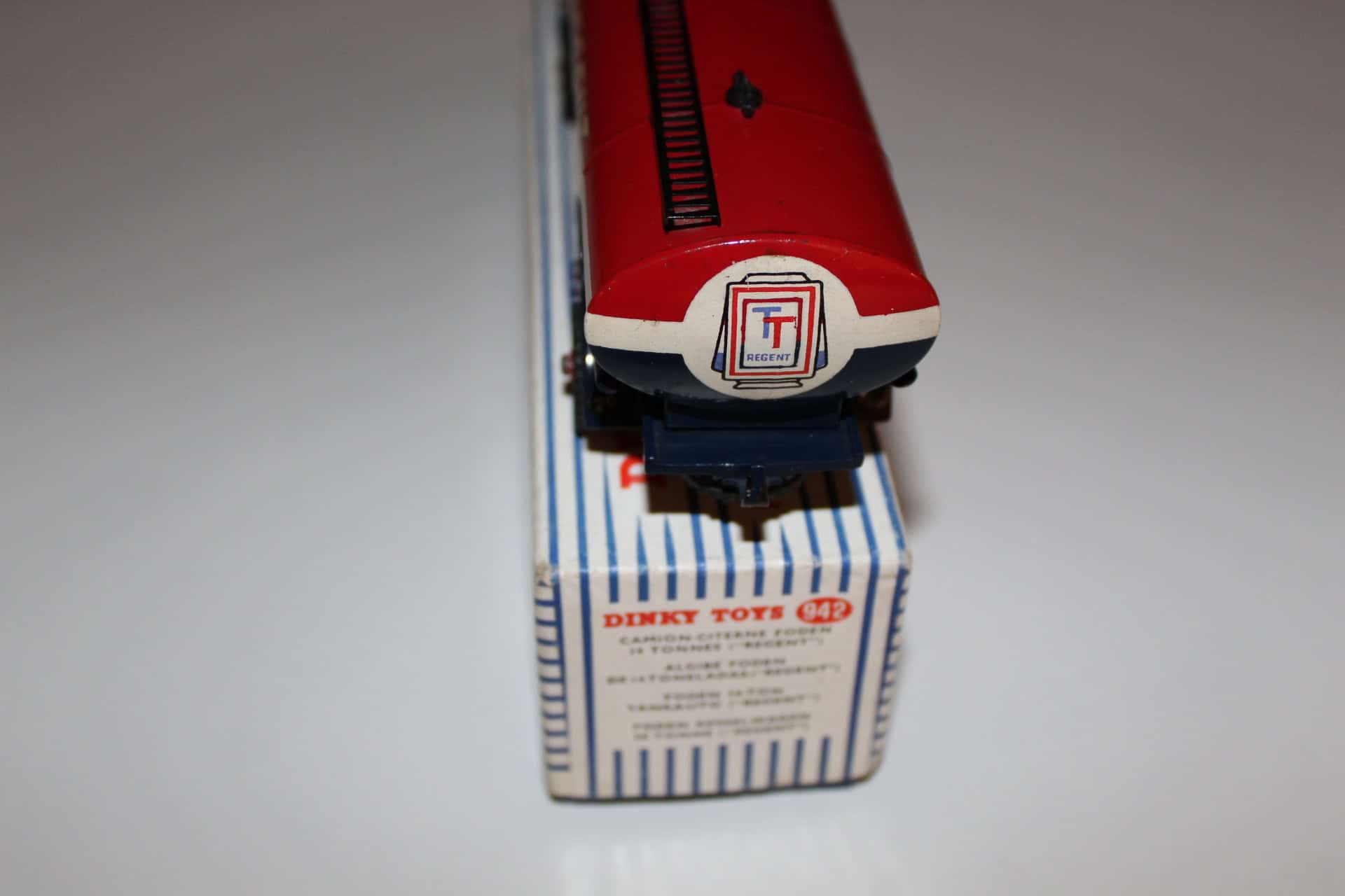 Detailed model of Dinky Toys 942 Foden Regent Tanker truck with red cab and blue and white striped t.