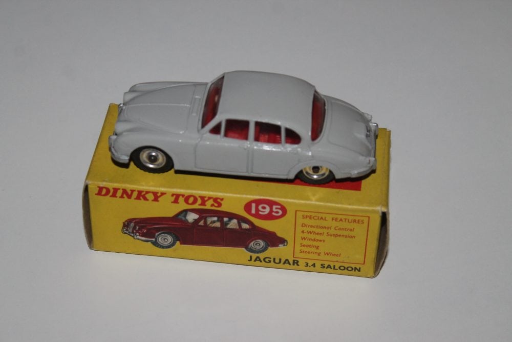Vintage diecast model of a grey Jaguar 3.4 saloon car on yellow box.