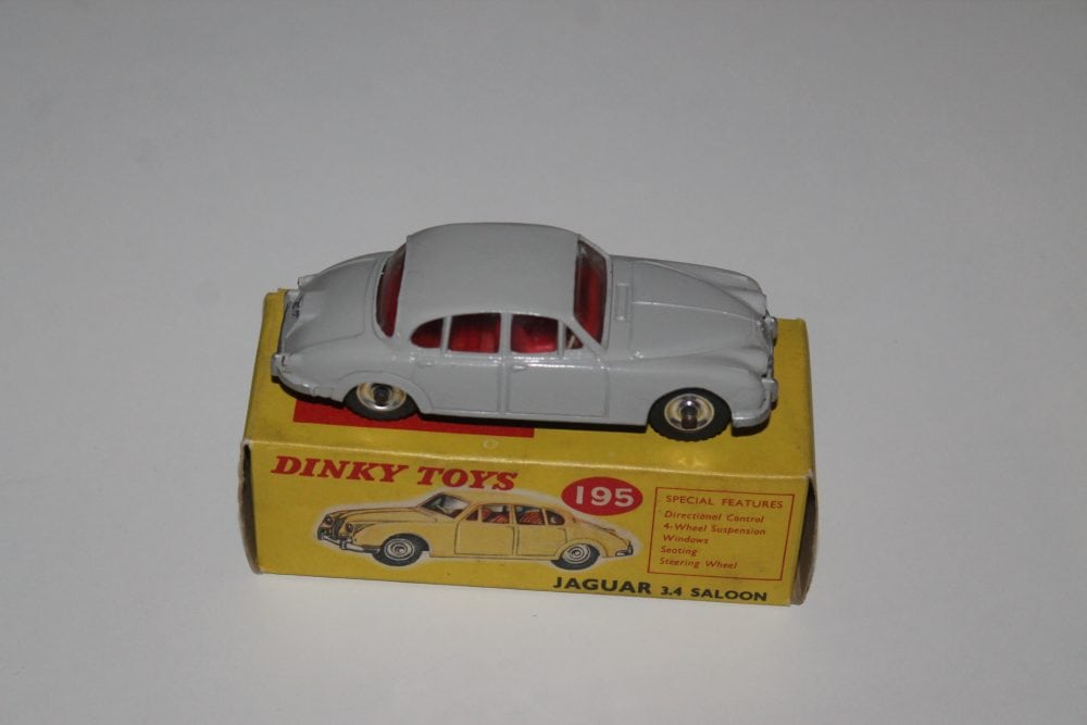 Dinky Toys 195 Grey Jaguar 3.4 model car on yellow box, collectible diecast toy.