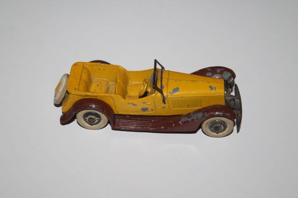 Vintage yellow and brown diecast model car with open top, collectible toy.