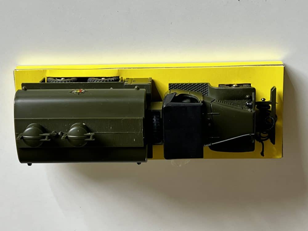 Vintage Dinky Toys 823 G.M.C military petrol tanker model on yellow background.