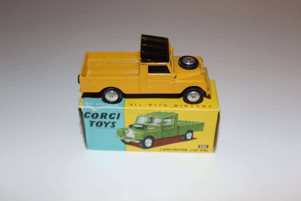 Vintage Corgi Toys Land Rover 406 model in yellow with black roof, displayed on original box.