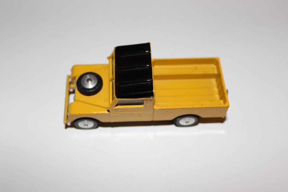 Vintage yellow and black diecast Land Rover toy model for collectors.