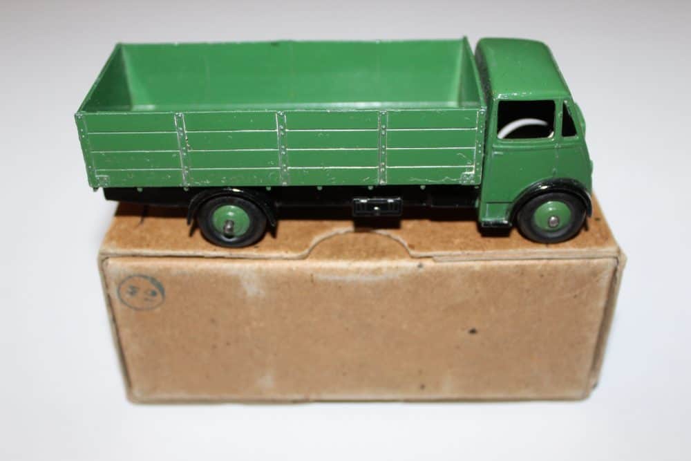 Vintage green diecast model of a Dinky Toys 511 Guy 4-Ton Lorry on a cardboard box.