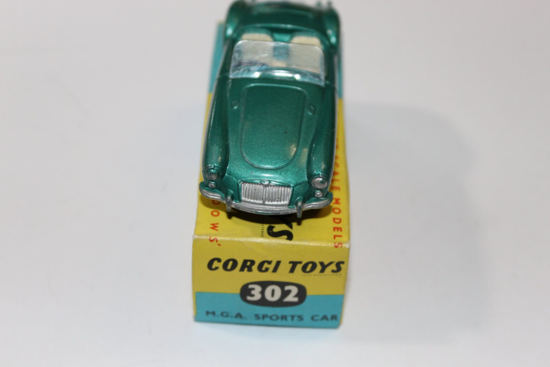 Detailed green diecast Corgi Toys 302 M.G.A. sports car on original box, collectible model.