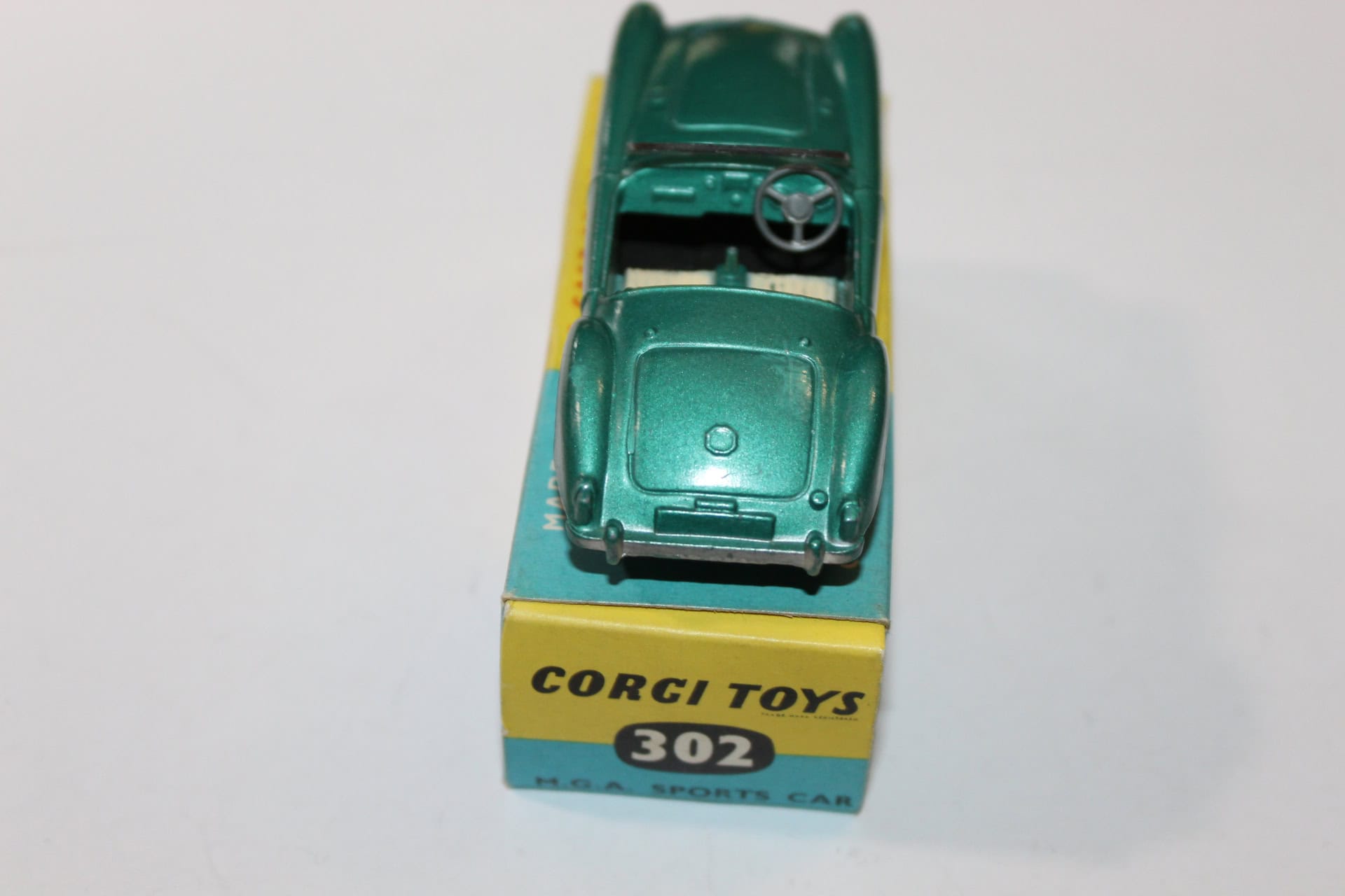 Vintage Corgi Toys 302 M.G.A. sports car model in green with yellow packaging.