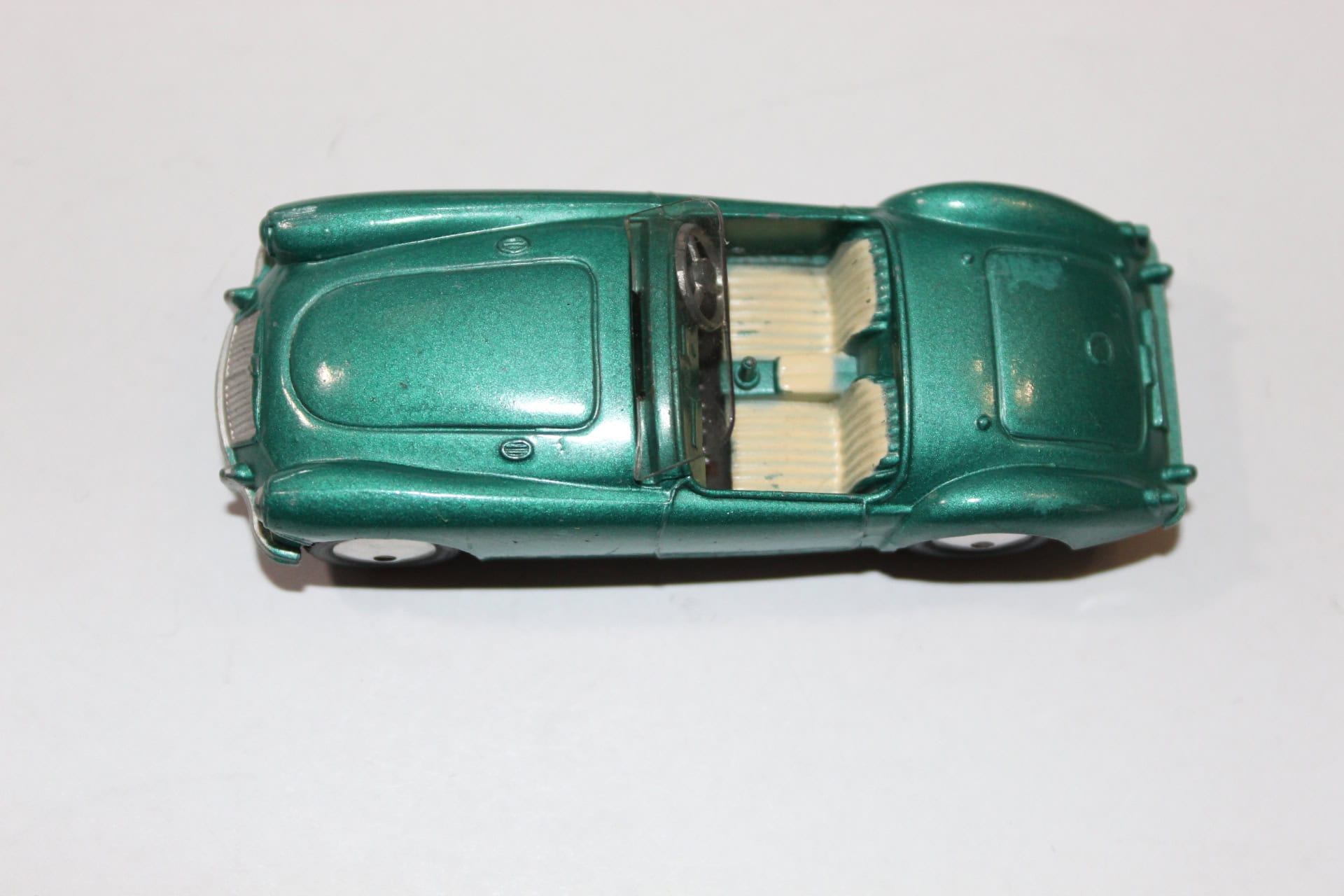 Vintage green diecast Corgi Toys 302 M.G.A. sports car with detailed interior and exterior.