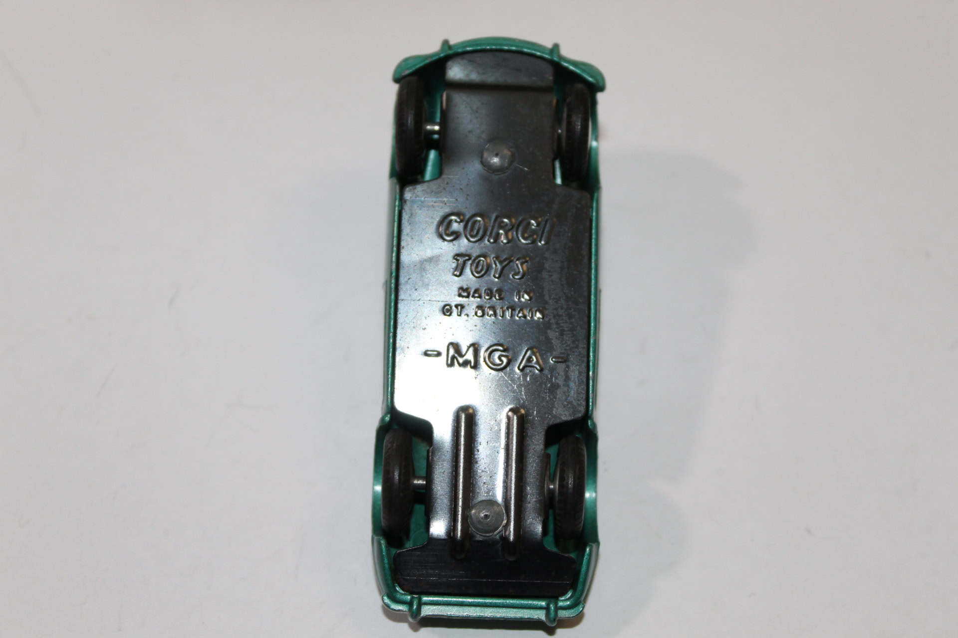 Vintage Corgi Toys 302 M.G.A. sports car model with detailed underside view.
