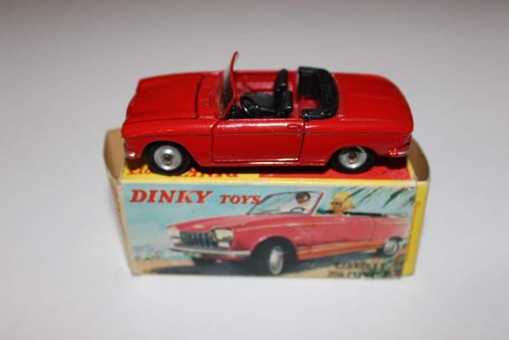 Vintage Dinky Toys French Peugeot Cabriolet model in red, displayed on original box.