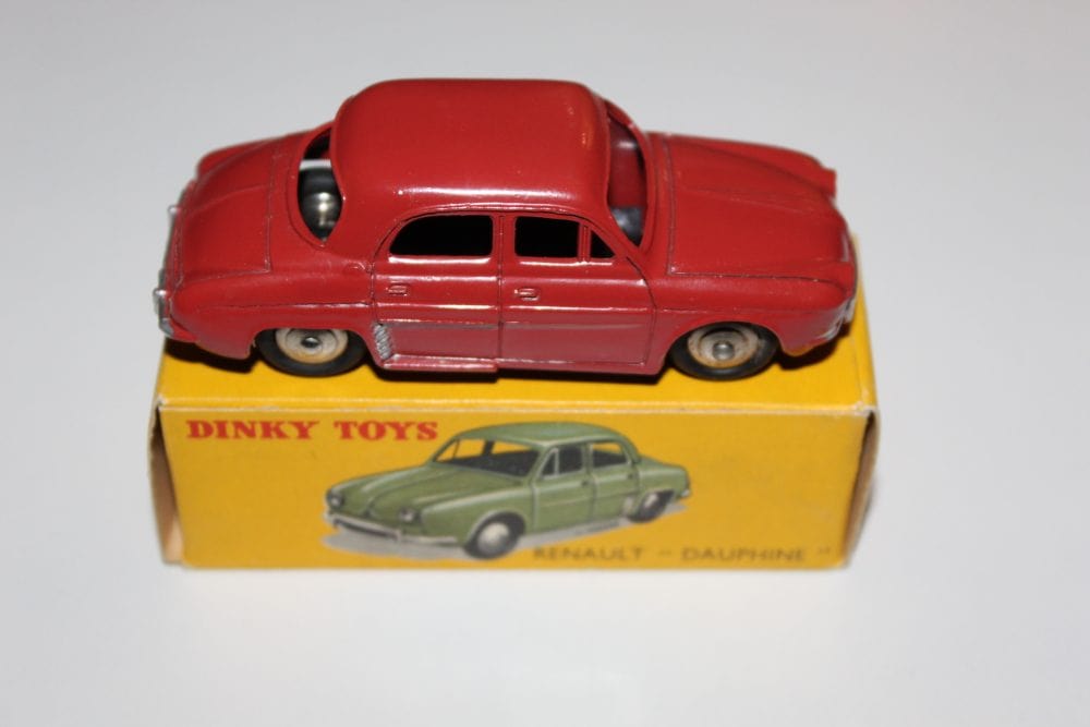 Vintage Dinky Toys 24E Renault Dauphine model car on yellow box.