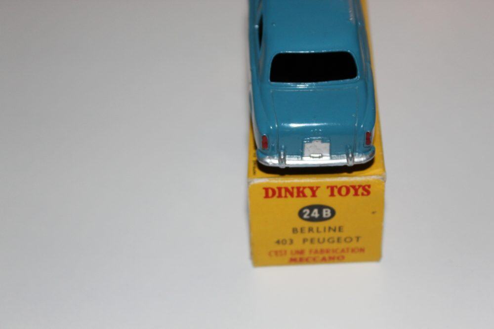 Dinky Toys 24B Peugeot 403 Berline vintage diecast model on yellow display stand.