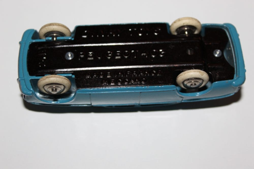 Vintage Dinky Toys 24B Peugeot 403 Berline model car, blue with white wheels, underside view.