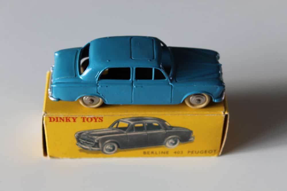 Vintage Dinky Toys 24B Peugeot 403 Berline model in blue on yellow box.