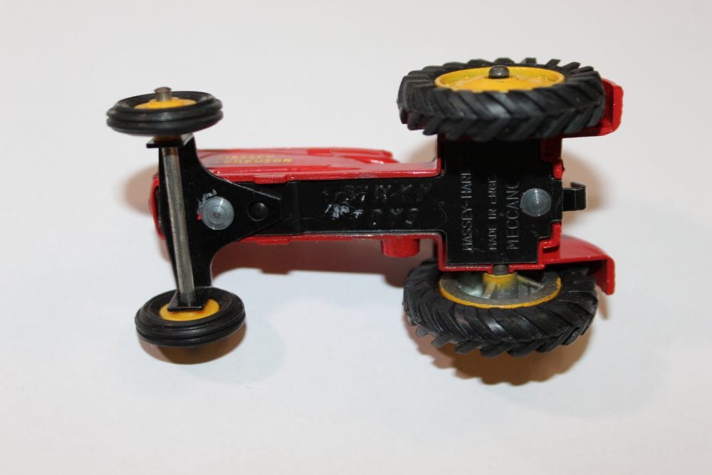 Vintage Dinky Toys Massey Ferguson tractor model with red body and black wheels.