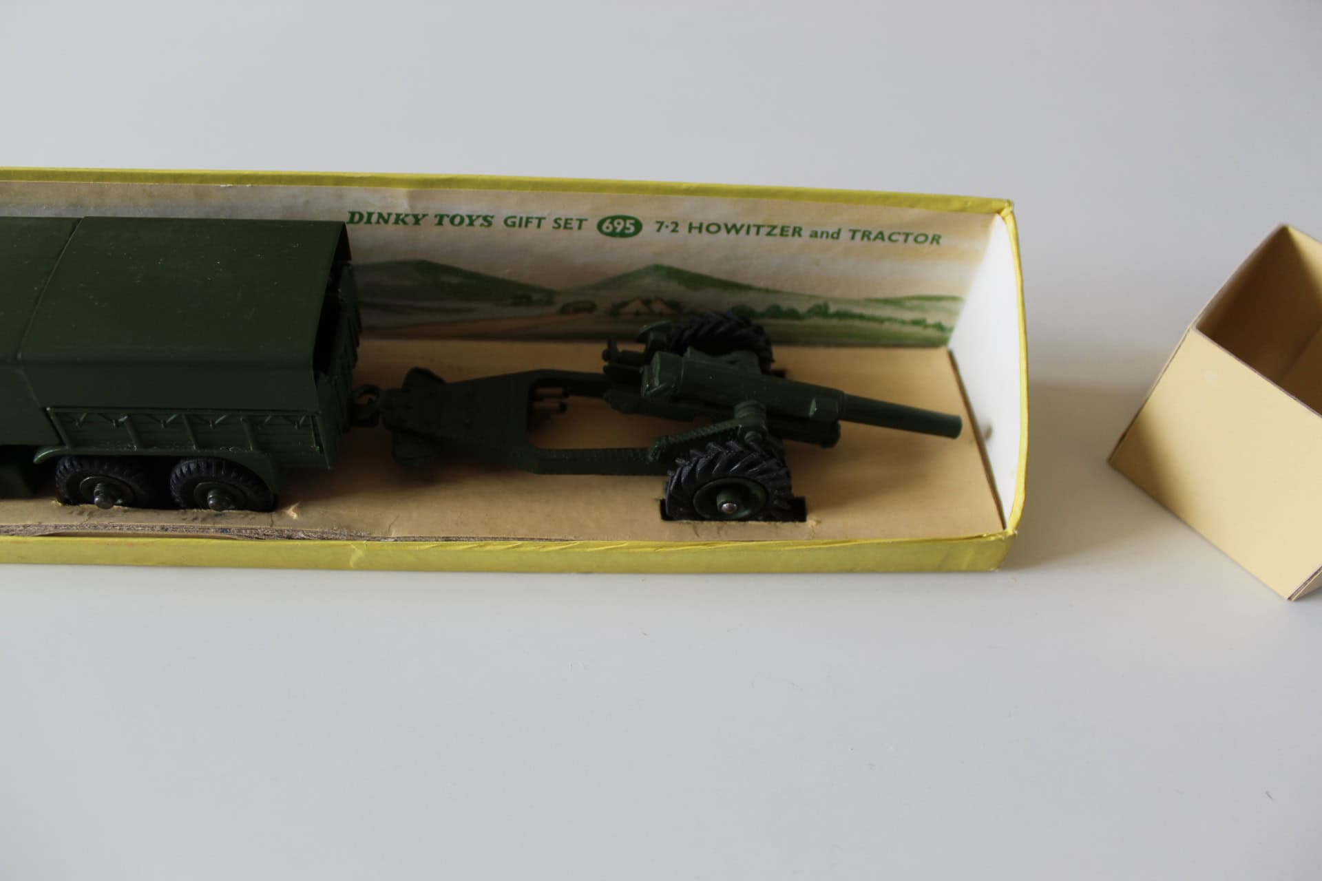 Detailed model of Dinky Toys 695 gift set featuring a green tractor and artillery gun.