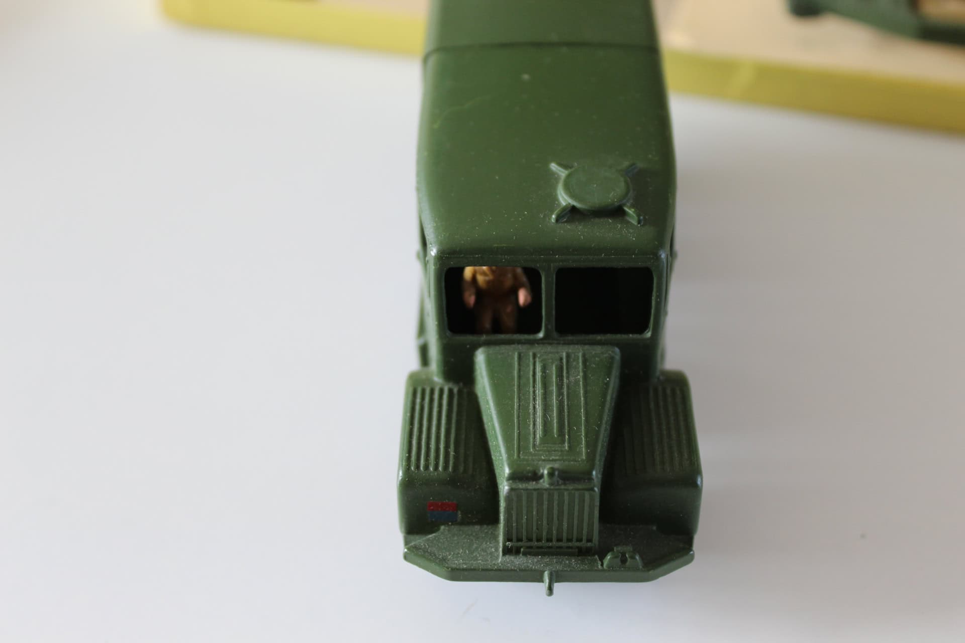 Vintage green diecast military toy vehicle with artillery and tractor features.