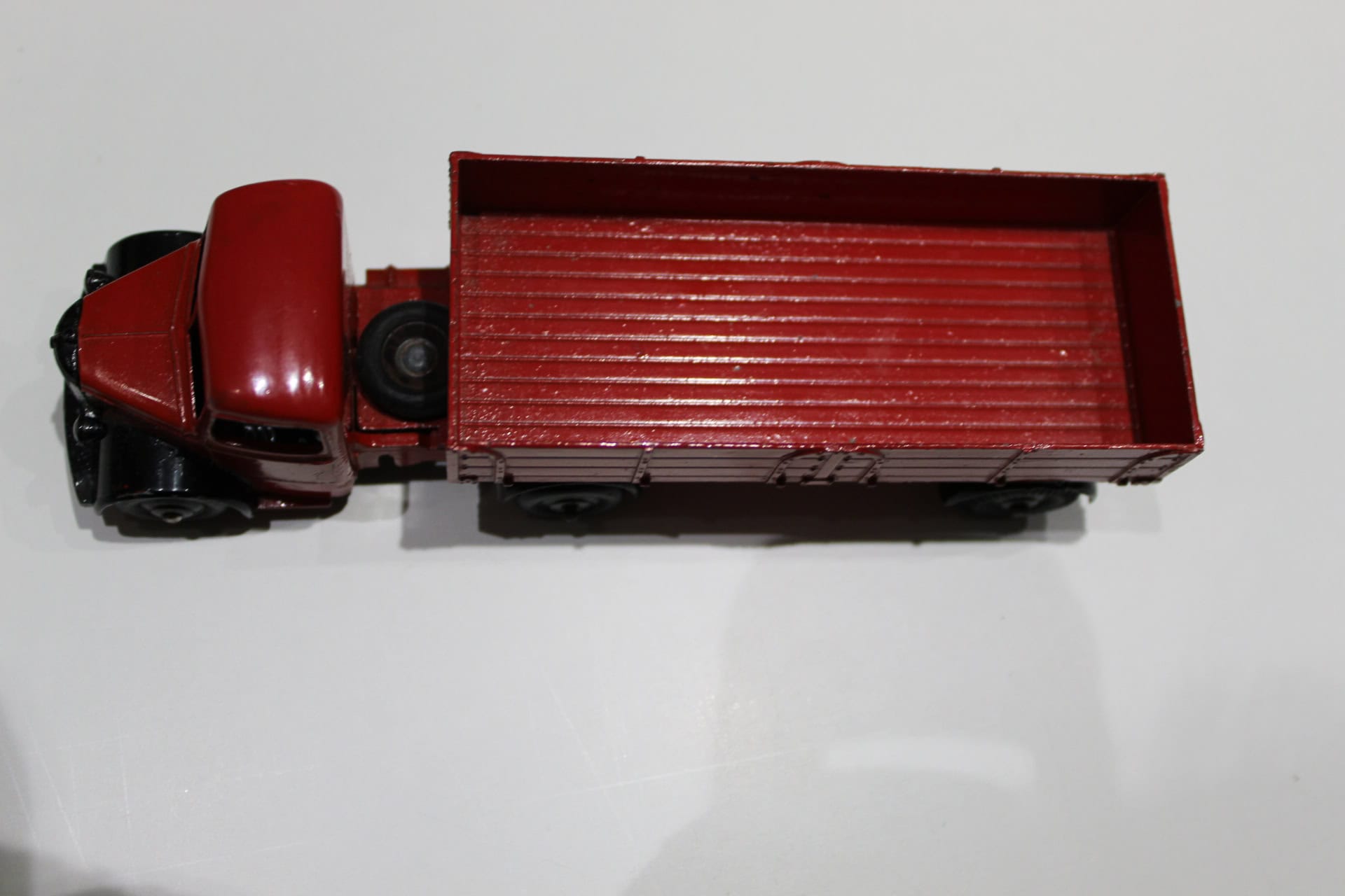 Vintage red Bedford articulated lorry toy model with detailed cargo bed.