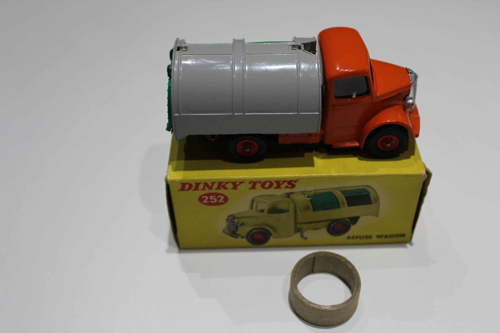 Vintage Dinky Toys refuse wagon with orange cab and grey tank, displayed on original box.