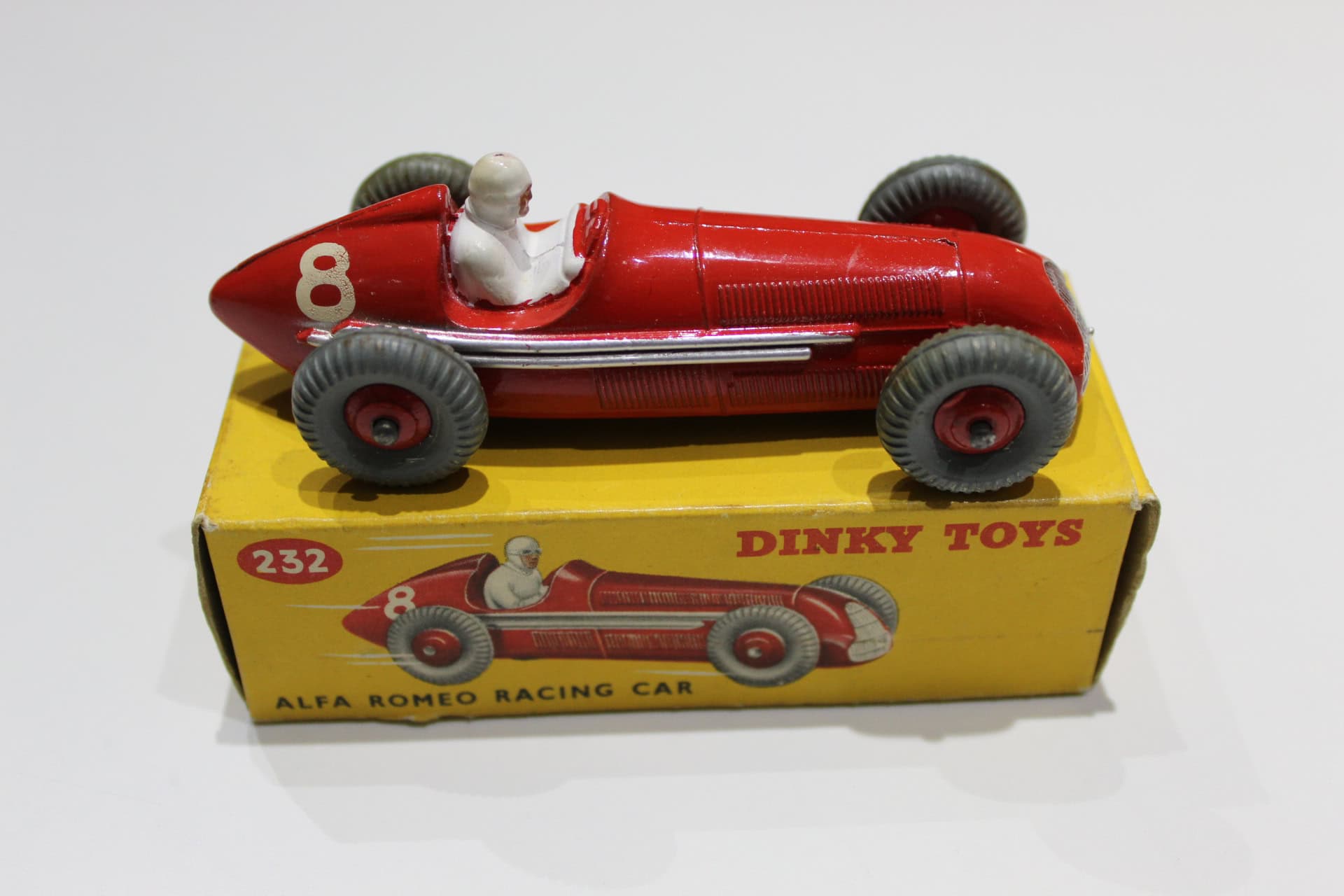 Vintage Dinky Toys 232 Alfa Romeo racing car model with red finish and black wheels.