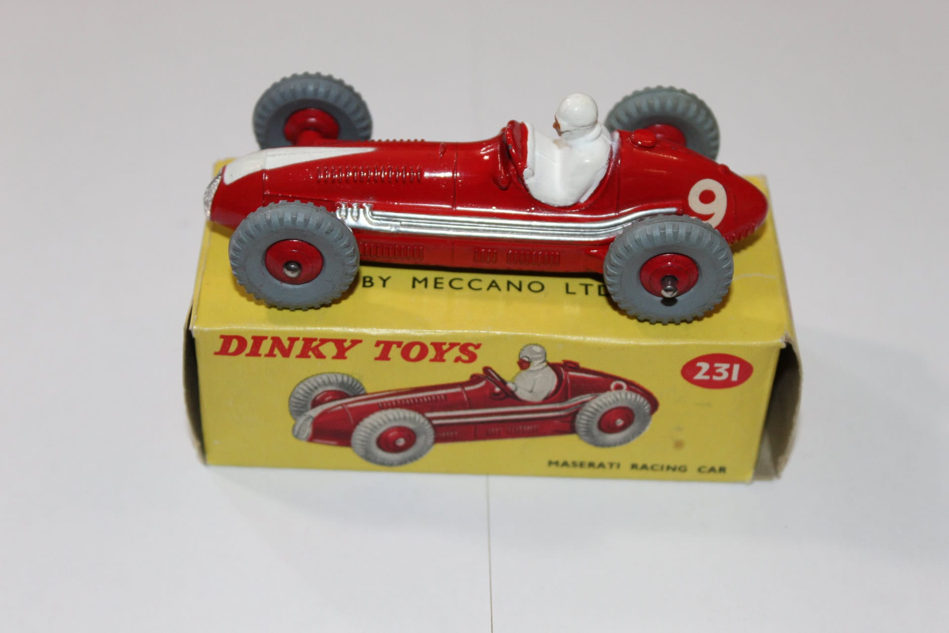 Vintage Dinky Toys 231 Maserati racing car with driver figure, yellow box, and red model.