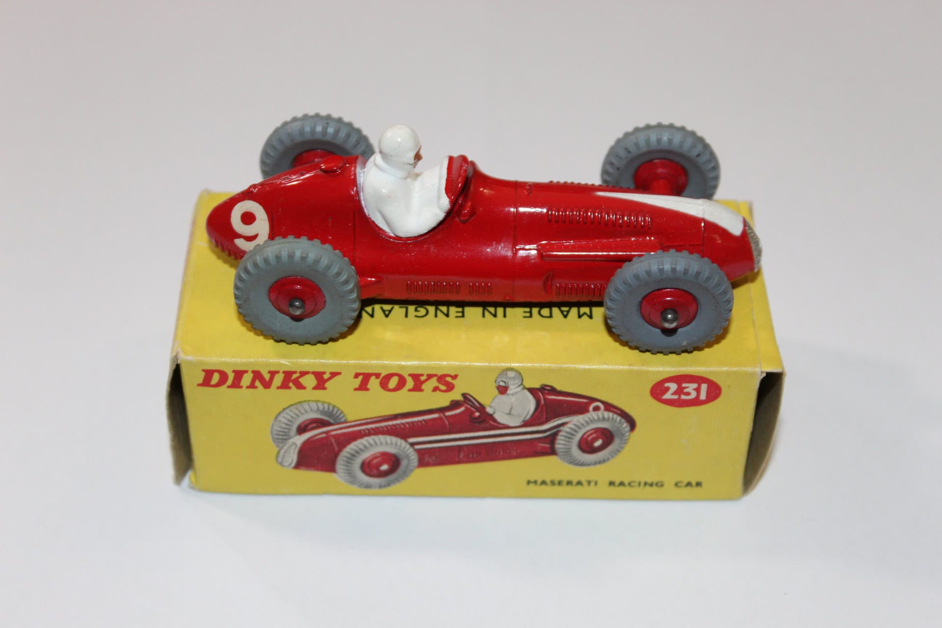 Vintage Dinky Toys 231 Maserati racing car model with red body and grey wheels.