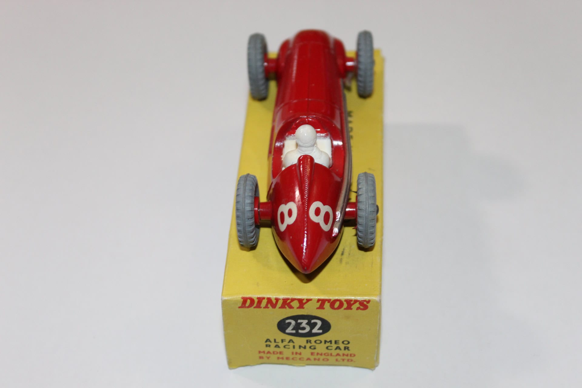 Vintage Dinky Toys 231 Maserati racing car model on yellow display stand.