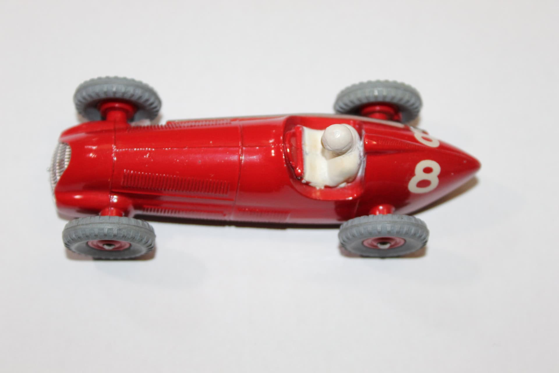 Vintage Dinky Toys 231 Maserati racing car in red with grey wheels.