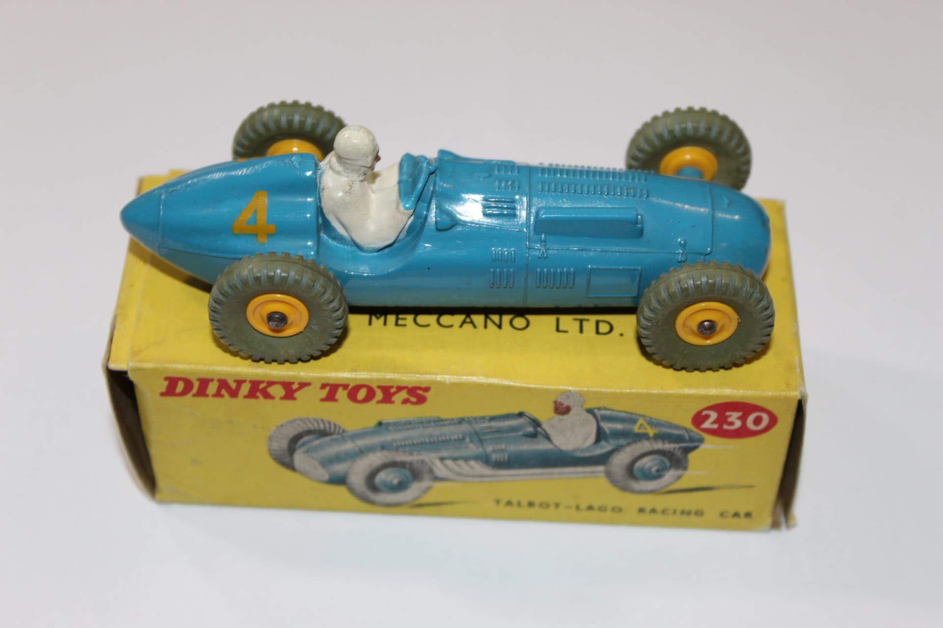 Vintage Dinky Toys 231 Maserati racing car with driver figure, yellow box, and black wheels.