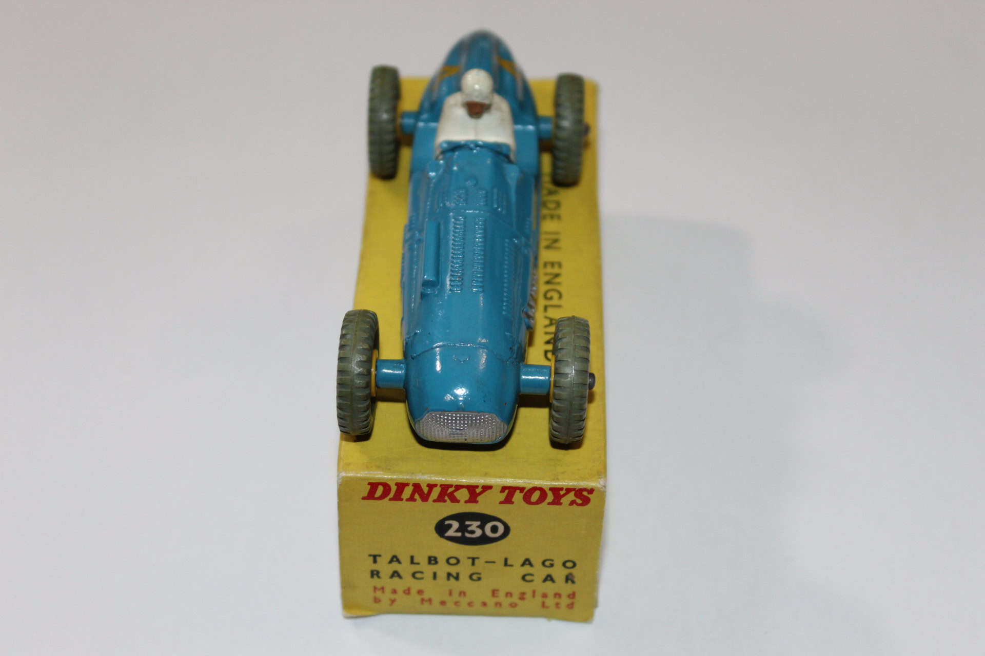 Dinky Toys 231 Maserati racing car model on yellow display stand, detailed vintage diecast vehicle.