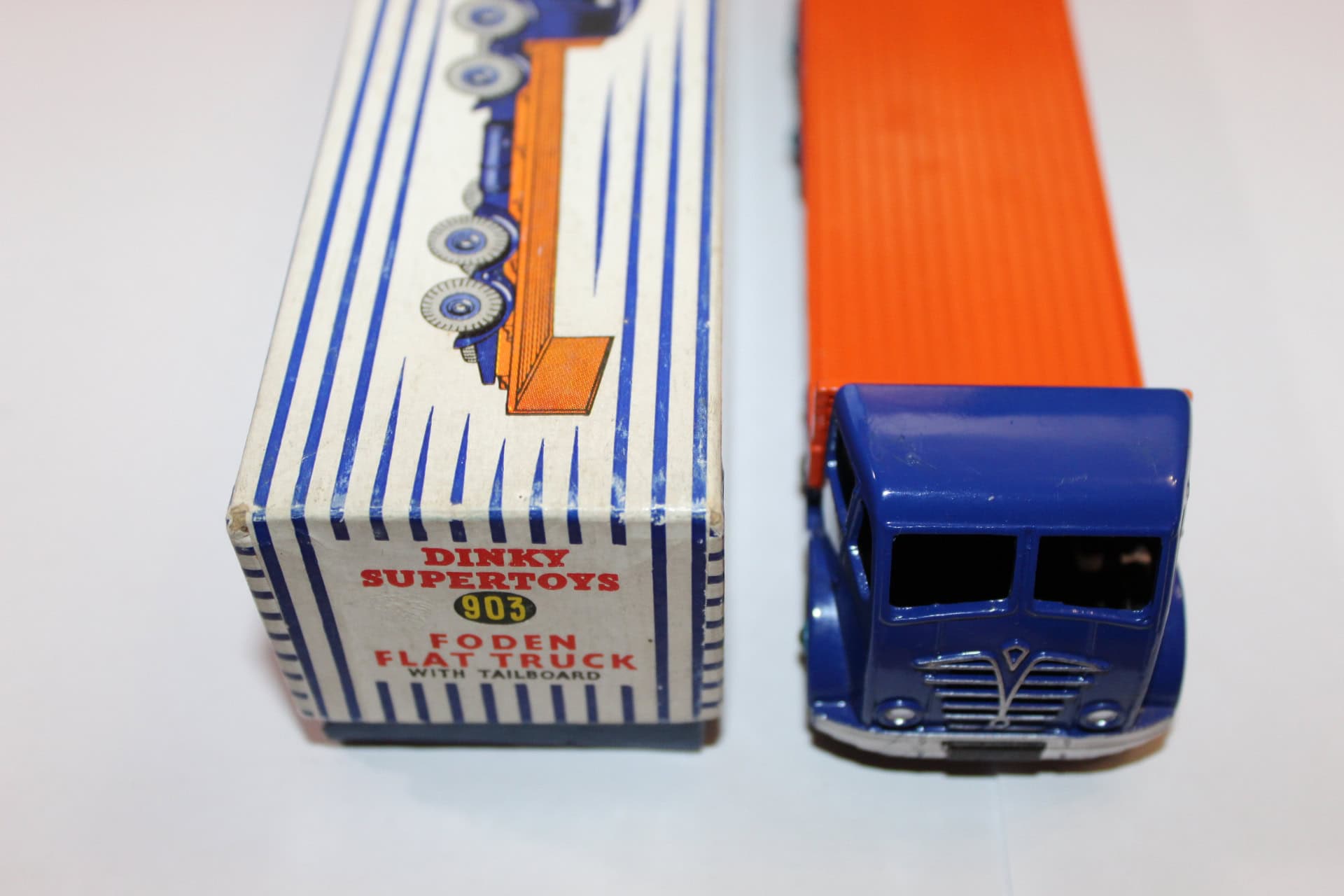 Dinky Toys 903 model flat truck with orange cargo bed and blue cab, vintage diecast toy.