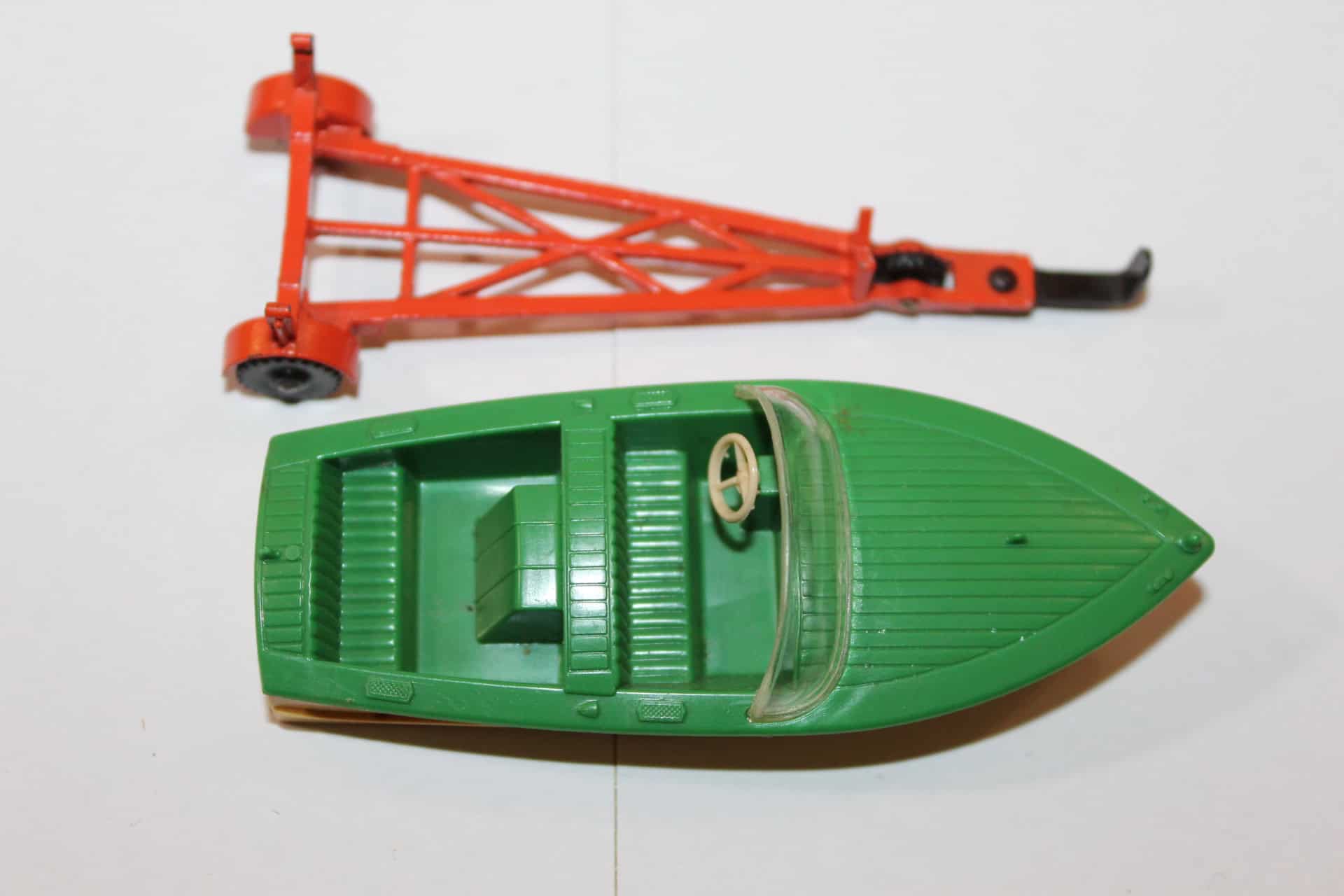 Vintage Dinky Toys green boat and orange trailer model for collectors.
