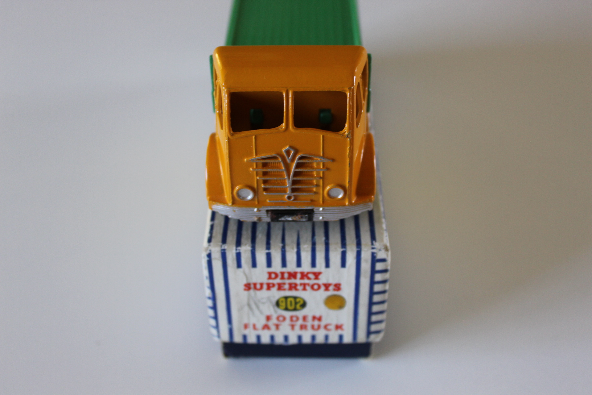 Diecast yellow flat truck toy with Dinky Supertoys branding, collectible model.