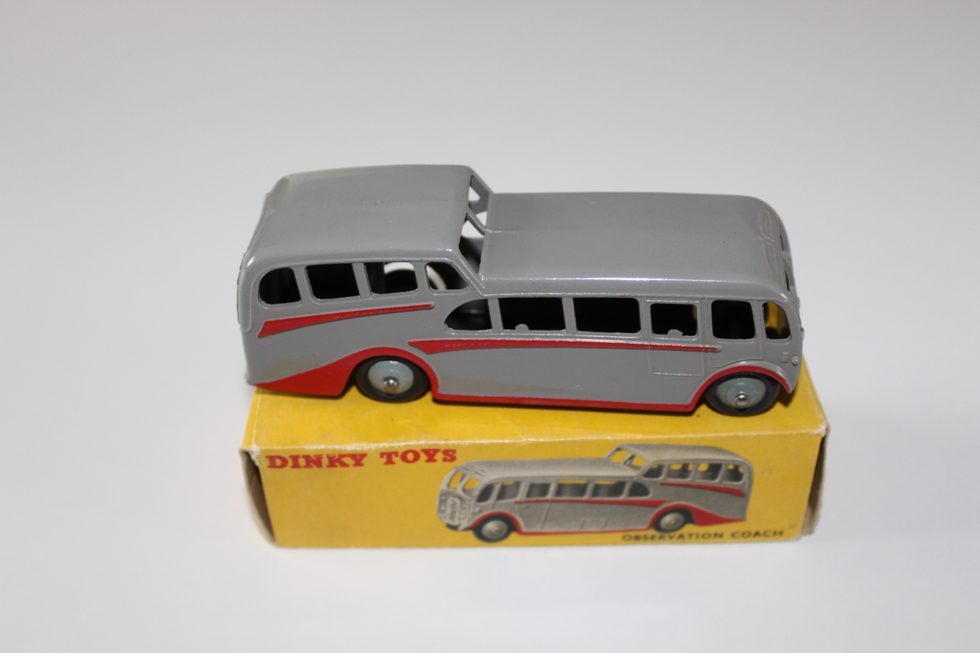 Vintage Dinky Toys observation coach model in grey with red stripe on yellow box.