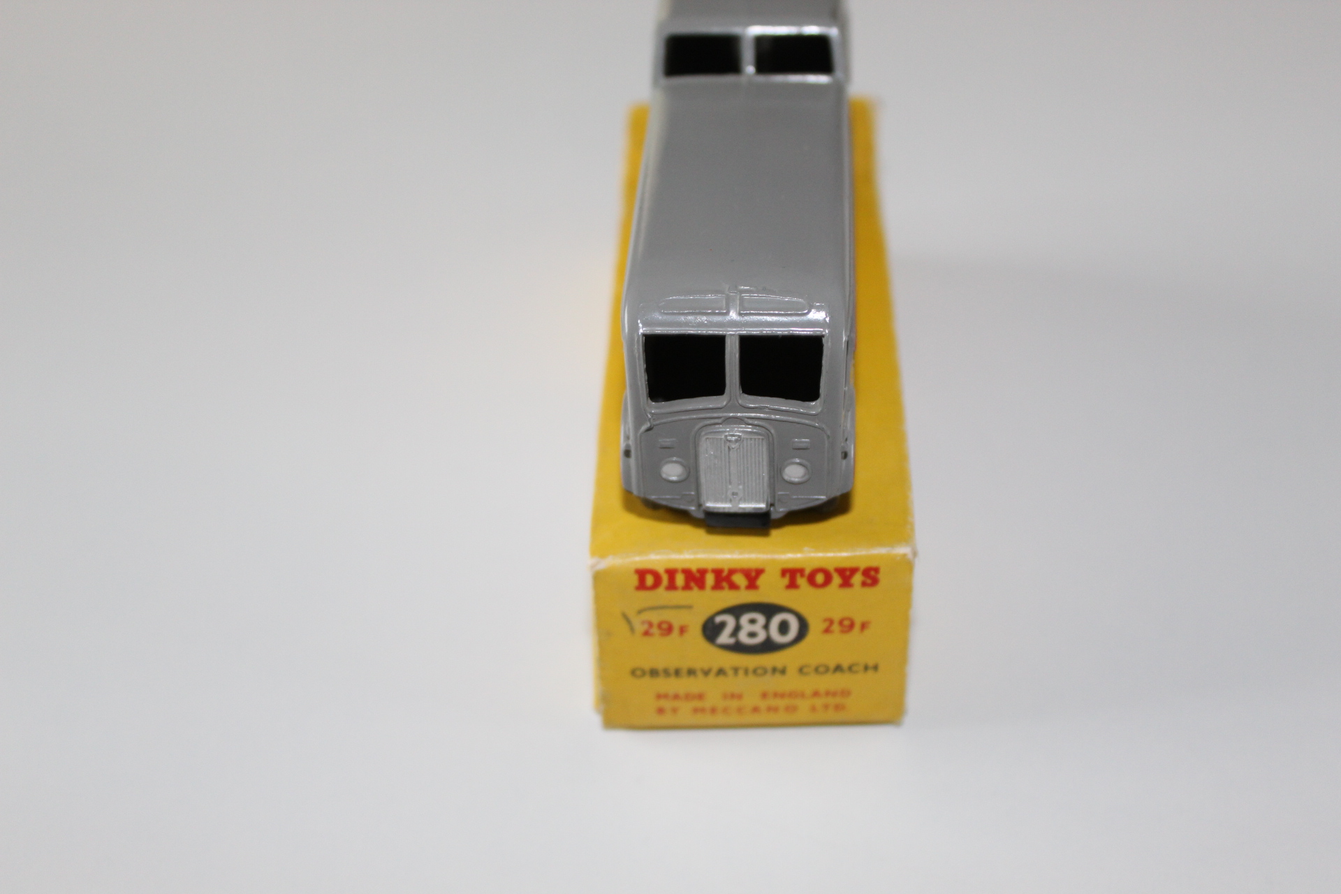 Vintage Dinky Toys observation coach model on yellow display box for collectors.