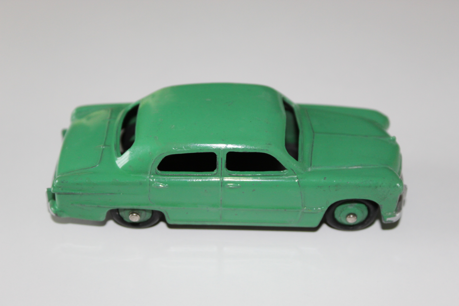Green vintage Dinky Toys 29F/280 observation coach model on white background.